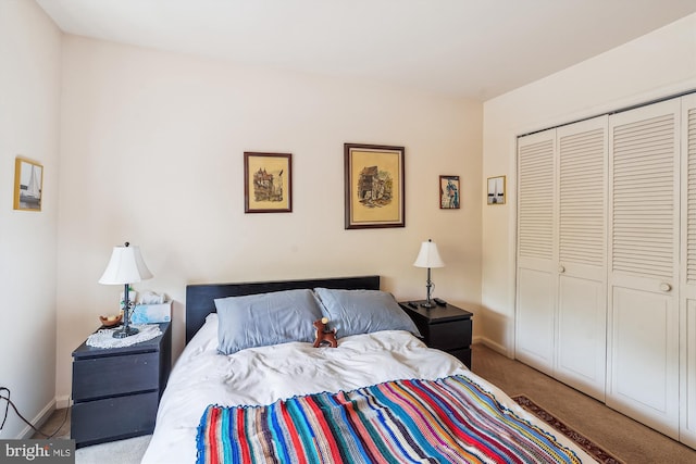 carpeted bedroom featuring a closet and baseboards