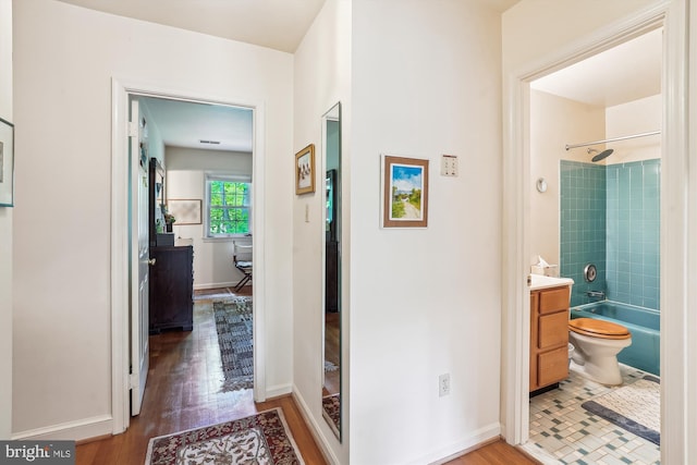 hall with wood finished floors and baseboards