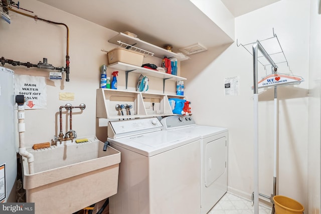 laundry area with a sink, laundry area, light floors, water heater, and separate washer and dryer
