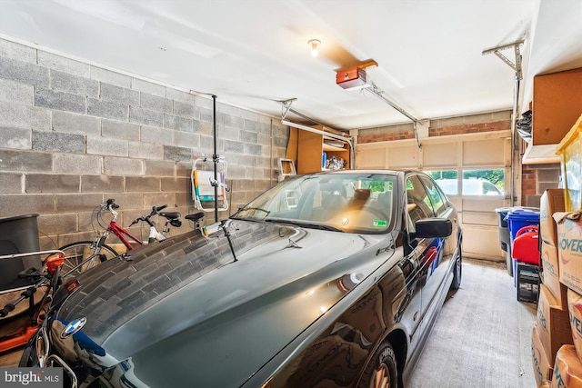 garage with concrete block wall and a garage door opener