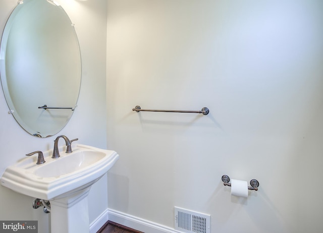 bathroom featuring visible vents, a sink, and baseboards