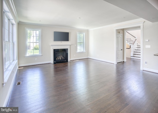 unfurnished living room with stairs, ornamental molding, and a wealth of natural light