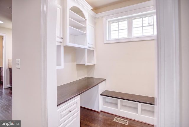 mudroom featuring dark wood-style flooring, visible vents, and built in study area