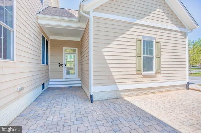 entrance to property with a shingled roof