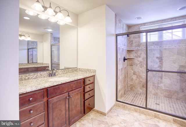 full bathroom featuring vanity, baseboards, and a stall shower