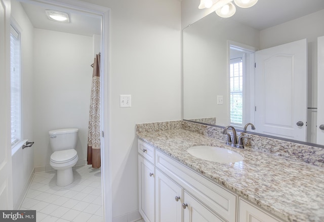 bathroom featuring baseboards, tile patterned floors, toilet, and vanity