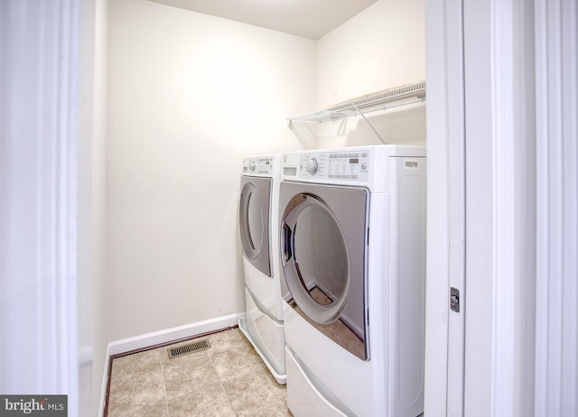 laundry area featuring separate washer and dryer, baseboards, laundry area, and visible vents