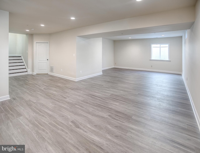 basement with stairway, baseboards, recessed lighting, and light wood-style flooring