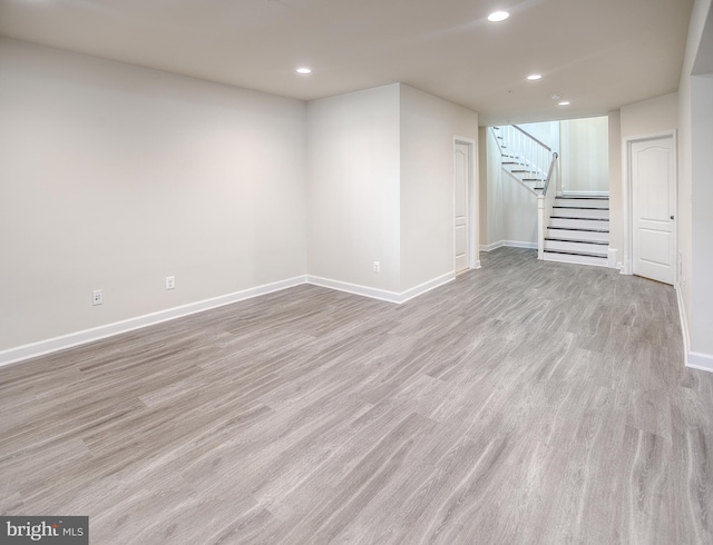 finished below grade area with stairs, recessed lighting, baseboards, and light wood finished floors