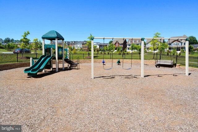 communal playground with fence and a residential view