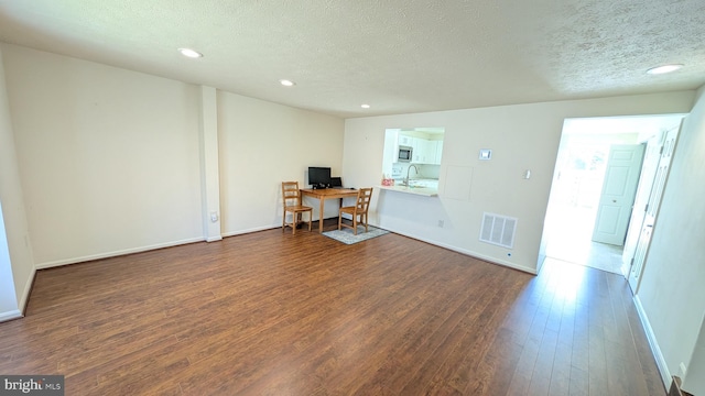 home office with visible vents, baseboards, recessed lighting, dark wood-type flooring, and a textured ceiling