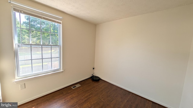 unfurnished room featuring baseboards, a textured ceiling, and dark wood-style flooring
