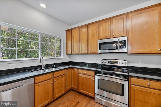 136 Roseville Ct, Boyce, VA 22620 - kitchen featuring brown cabinetry, a sink, dark stone counters, stainless steel appliances, and light wood-style flooring