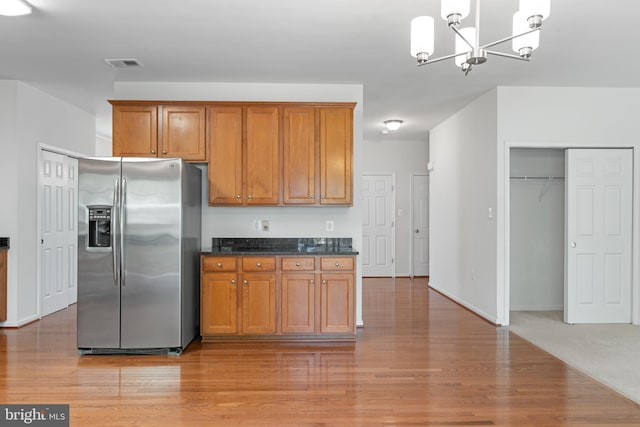 136 Roseville Ct, Boyce, VA 22620 - kitchen with brown cabinetry, visible vents, an inviting chandelier, stainless steel fridge, and light wood-type flooring