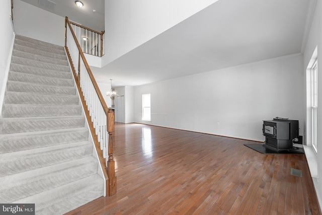 136 Roseville Ct, Boyce, VA 22620 - unfurnished living room with a wood stove, a chandelier, wood finished floors, and stairway