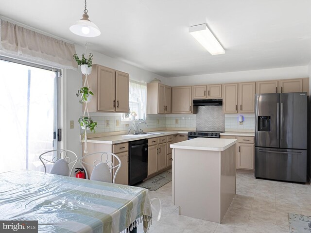 kitchen with decorative backsplash, light countertops, under cabinet range hood, a sink, and appliances with stainless steel finishes
