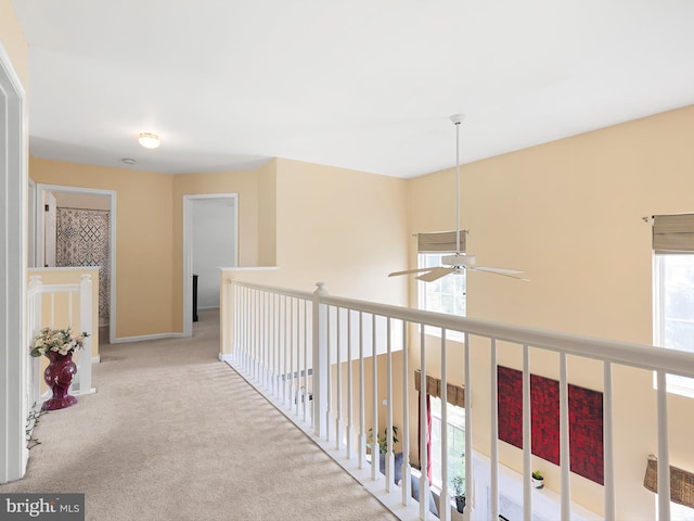 hall featuring carpet flooring and baseboards
