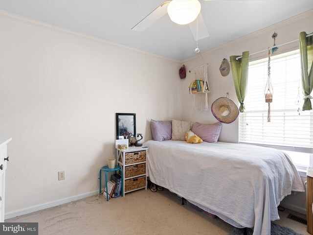 carpeted bedroom featuring crown molding, baseboards, and a ceiling fan