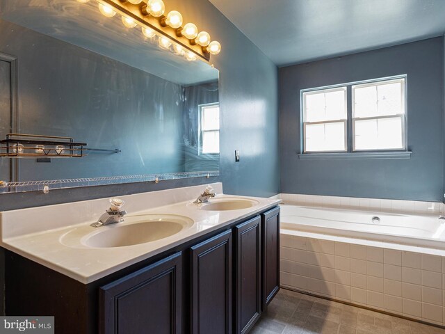 full bath with a healthy amount of sunlight, a sink, and a garden tub