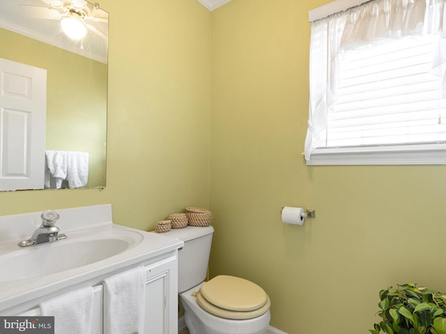 half bathroom with vanity, ornamental molding, a ceiling fan, and toilet