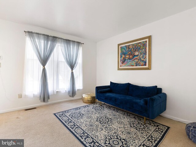 living area featuring carpet floors, baseboards, and visible vents