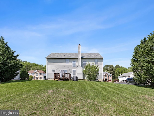 rear view of property with a chimney and a yard