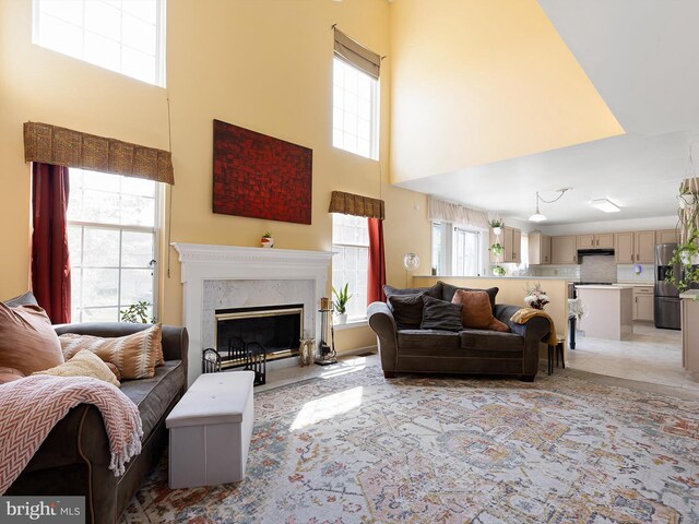 living area with a fireplace and a towering ceiling