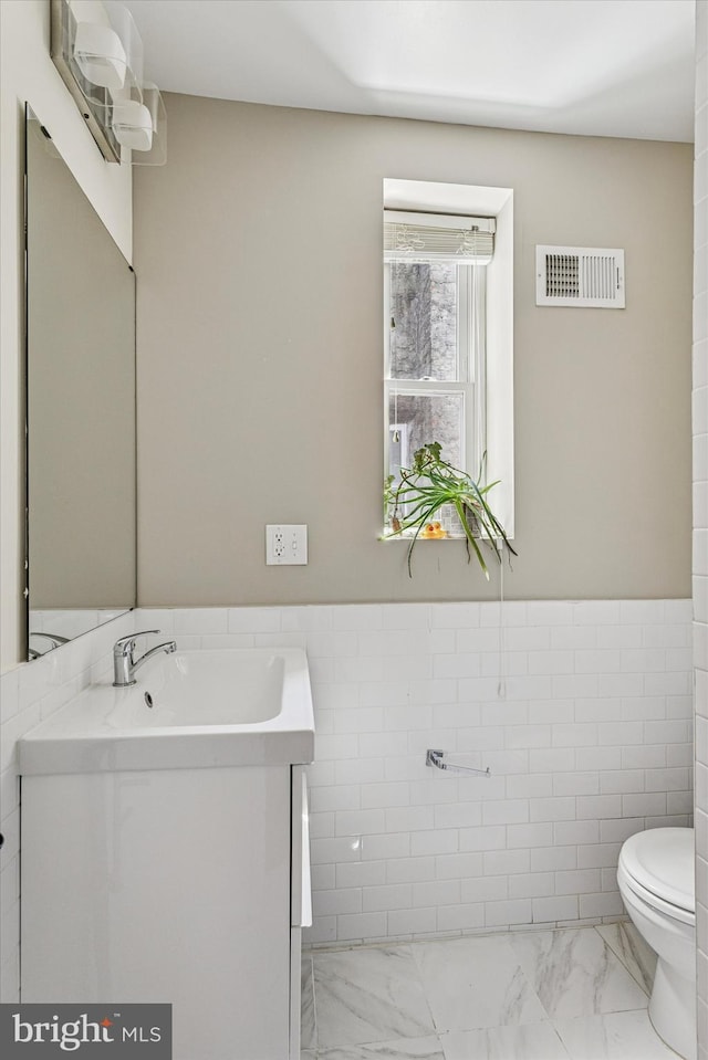 538 Moore St, Philadelphia, PA 19148 - bathroom featuring visible vents, tile walls, vanity, toilet, and marble finish floor