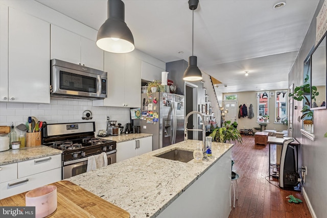 538 Moore St, Philadelphia, PA 19148 - kitchen with white cabinets, stainless steel appliances, a sink, and backsplash