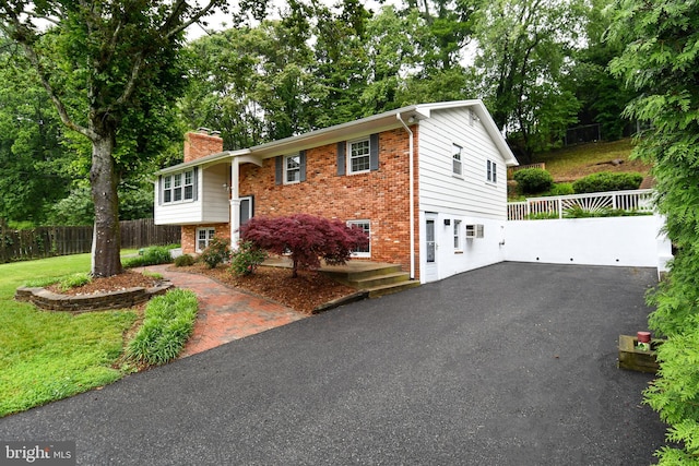 130 Great Lake Dr, Annapolis, MD 21403 - bi-level home with brick siding, asphalt driveway, a chimney, and fence