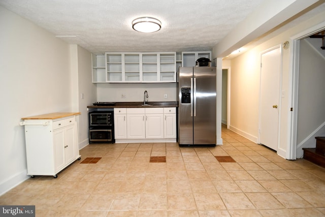 130 Great Lake Dr, Annapolis, MD 21403 - kitchen featuring stainless steel fridge, open shelves, a sink, white cabinets, and a textured ceiling