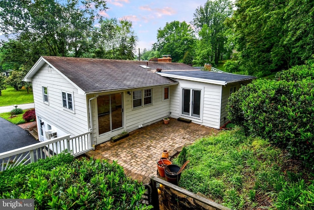 130 Great Lake Dr, Annapolis, MD 21403 - rear view of property with a chimney, a shingled roof, a patio, and view of wooded area