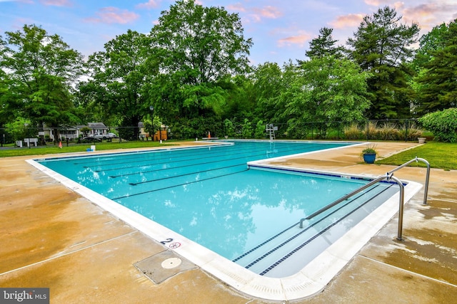 130 Great Lake Dr, Annapolis, MD 21403 - pool at dusk featuring a community pool, fence, and view of wooded area