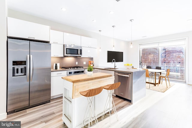 1350 Maryland Ave NE Unit 116, Washington, DC 20002 - kitchen with white cabinets, appliances with stainless steel finishes, wood counters, a peninsula, and a kitchen island
