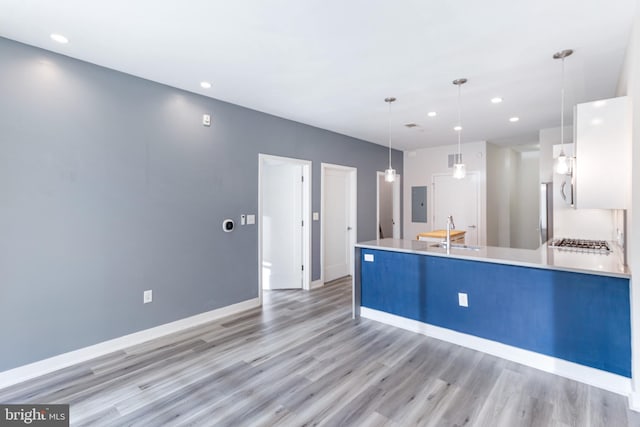 1350 Maryland Ave NE Unit 116, Washington, DC 20002 - kitchen with a sink, light countertops, a peninsula, stainless steel gas stovetop, and light wood-style flooring