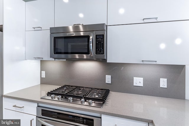 1350 Maryland Ave NE Unit 116, Washington, DC 20002 - kitchen with decorative backsplash, modern cabinets, light stone counters, white cabinets, and stainless steel appliances