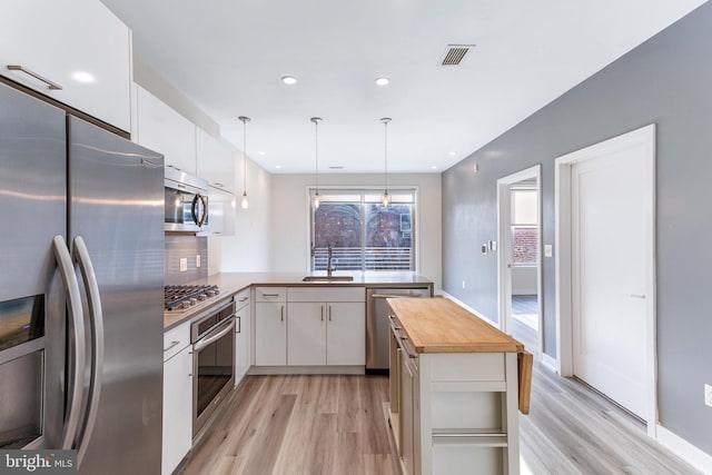 1350 Maryland Ave NE Unit 116, Washington, DC 20002 - kitchen with visible vents, light wood finished floors, wooden counters, and stainless steel appliances