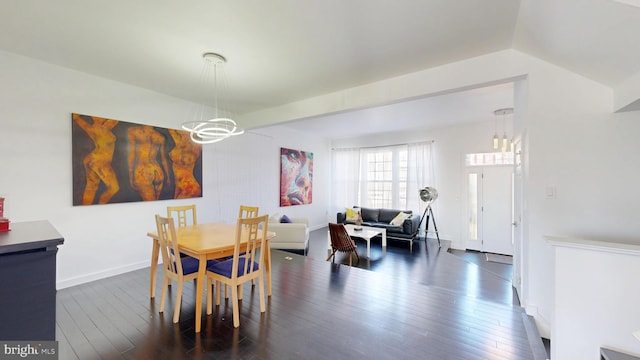 dining space featuring baseboards, dark wood-type flooring, and a chandelier