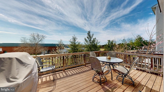 deck with outdoor dining space and area for grilling