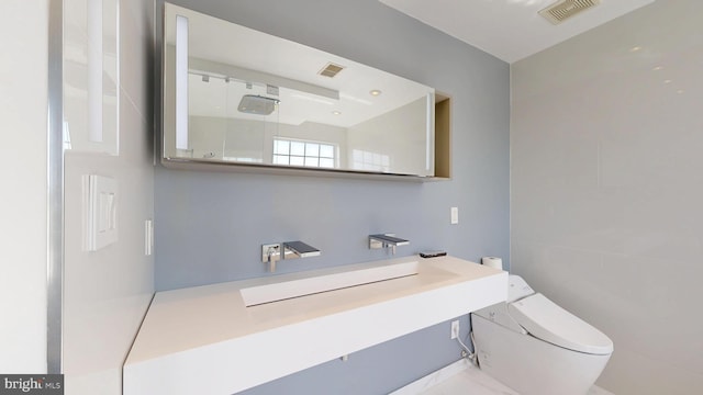 bathroom with visible vents, a shower, toilet, and vanity