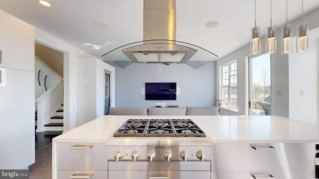 kitchen featuring light countertops, open floor plan, vaulted ceiling, and island exhaust hood
