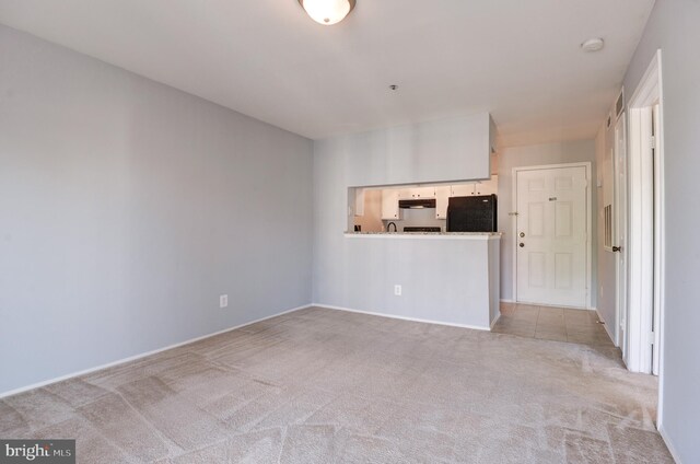 carpeted spare room featuring baseboards and visible vents