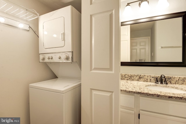 washroom featuring a sink, laundry area, and stacked washer and dryer