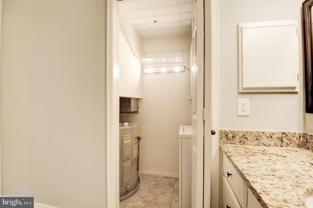 bathroom featuring water heater, vanity, and washer / dryer