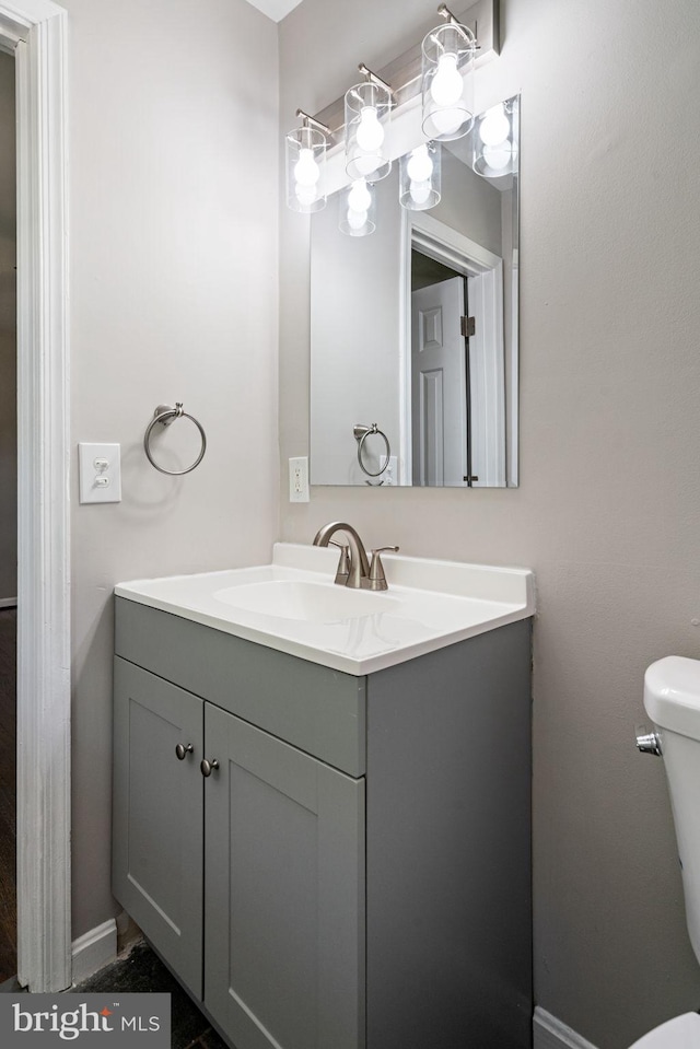 half bathroom featuring vanity and toilet