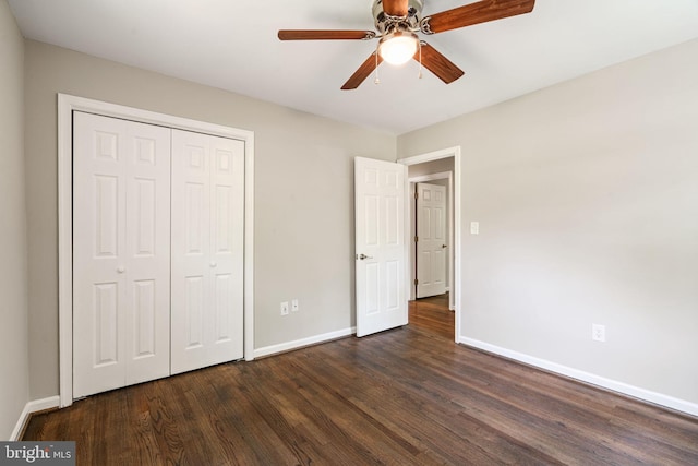 unfurnished bedroom featuring baseboards, dark wood-style floors, ceiling fan, and a closet