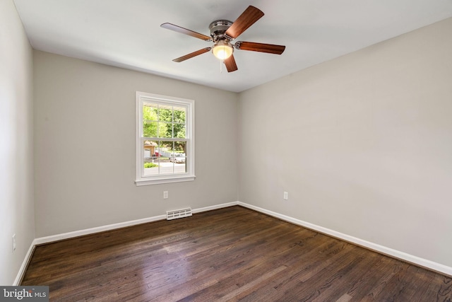 empty room featuring baseboards, visible vents, ceiling fan, and dark wood-type flooring