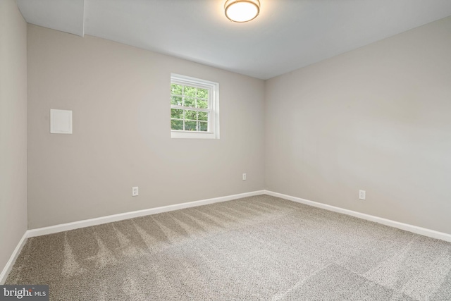 unfurnished room with carpet flooring and baseboards