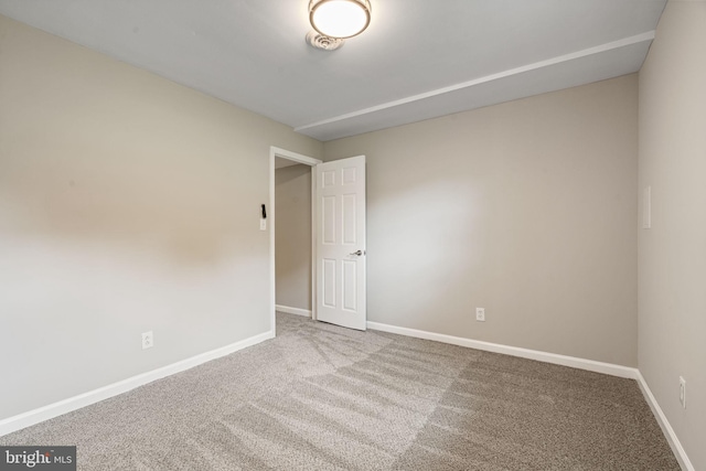 unfurnished room featuring carpet floors and baseboards