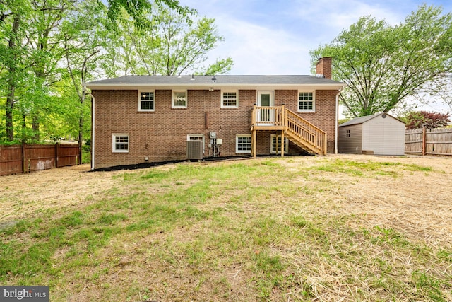 back of house with a chimney, brick siding, fence, an outdoor structure, and a yard